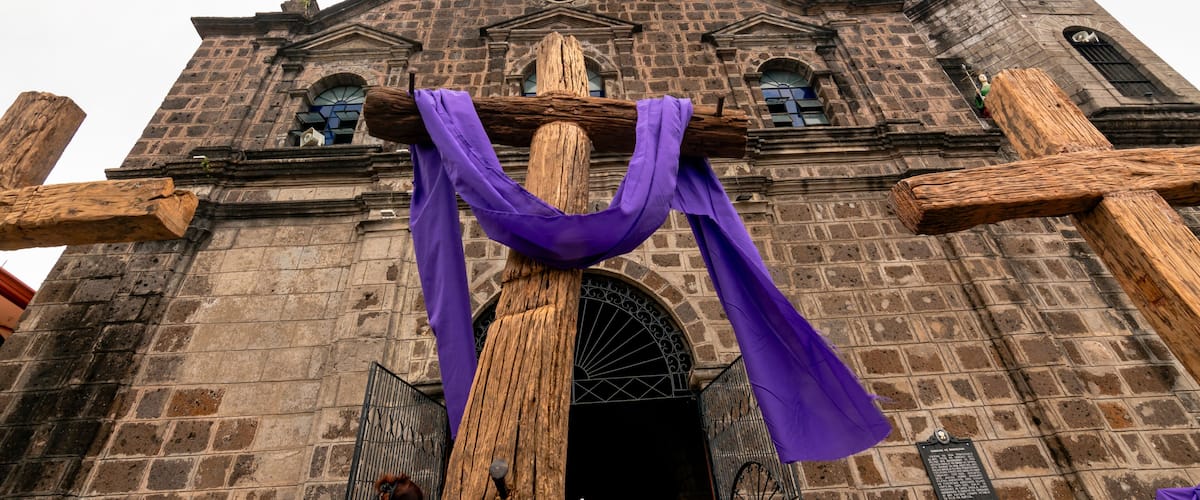 A historic church with large wooden crosses and purple drapes.