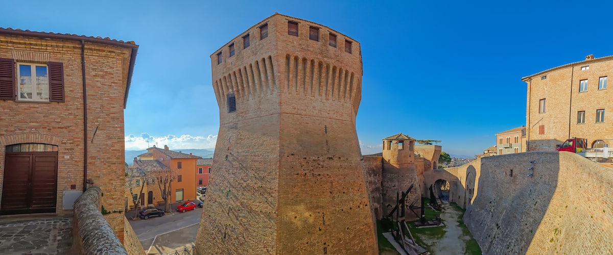 A historic stone tower, narrow medieval streets, and traditional buildings.