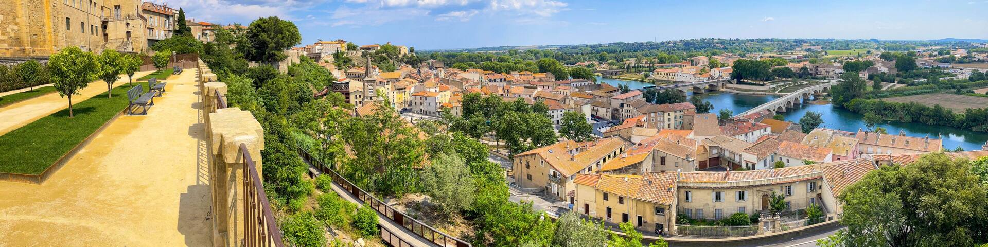 A historic town with a river, a bridge, and a prominent building with a tower.