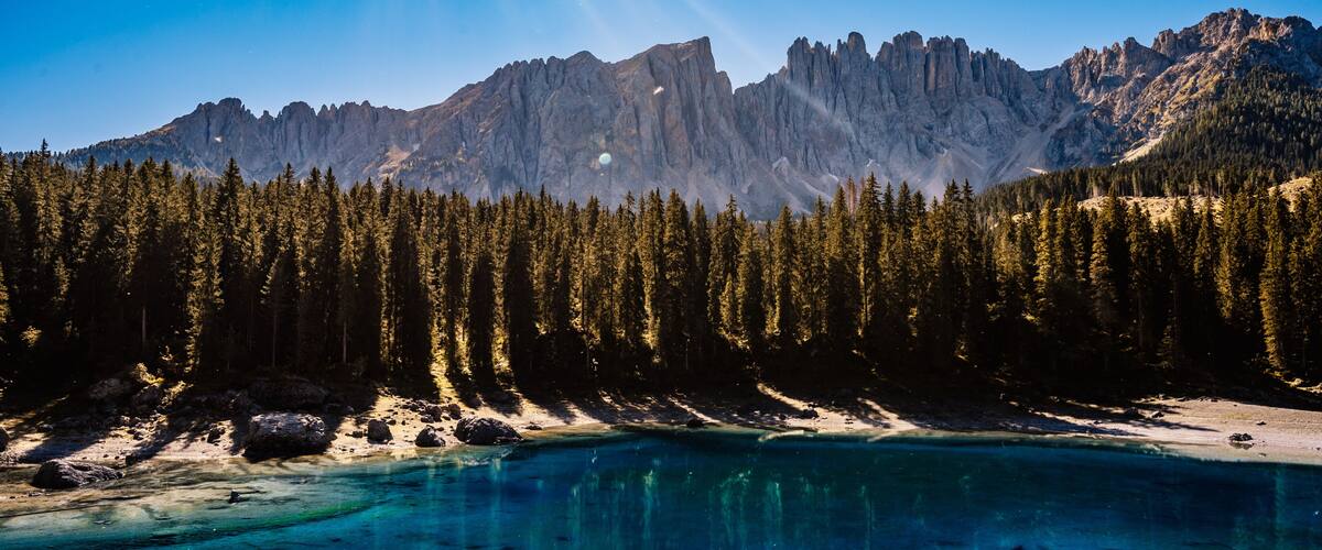 A mountain range with a clear lake in the foreground.