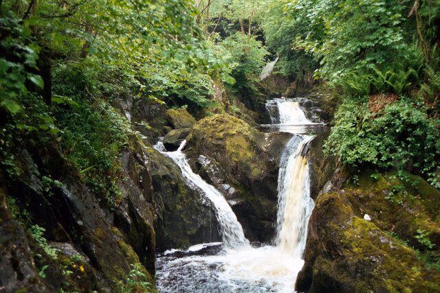 A waterfall surrounded by lush greenery.