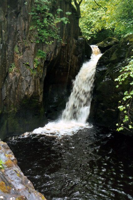 A waterfall cascading over rocks in a forested area.