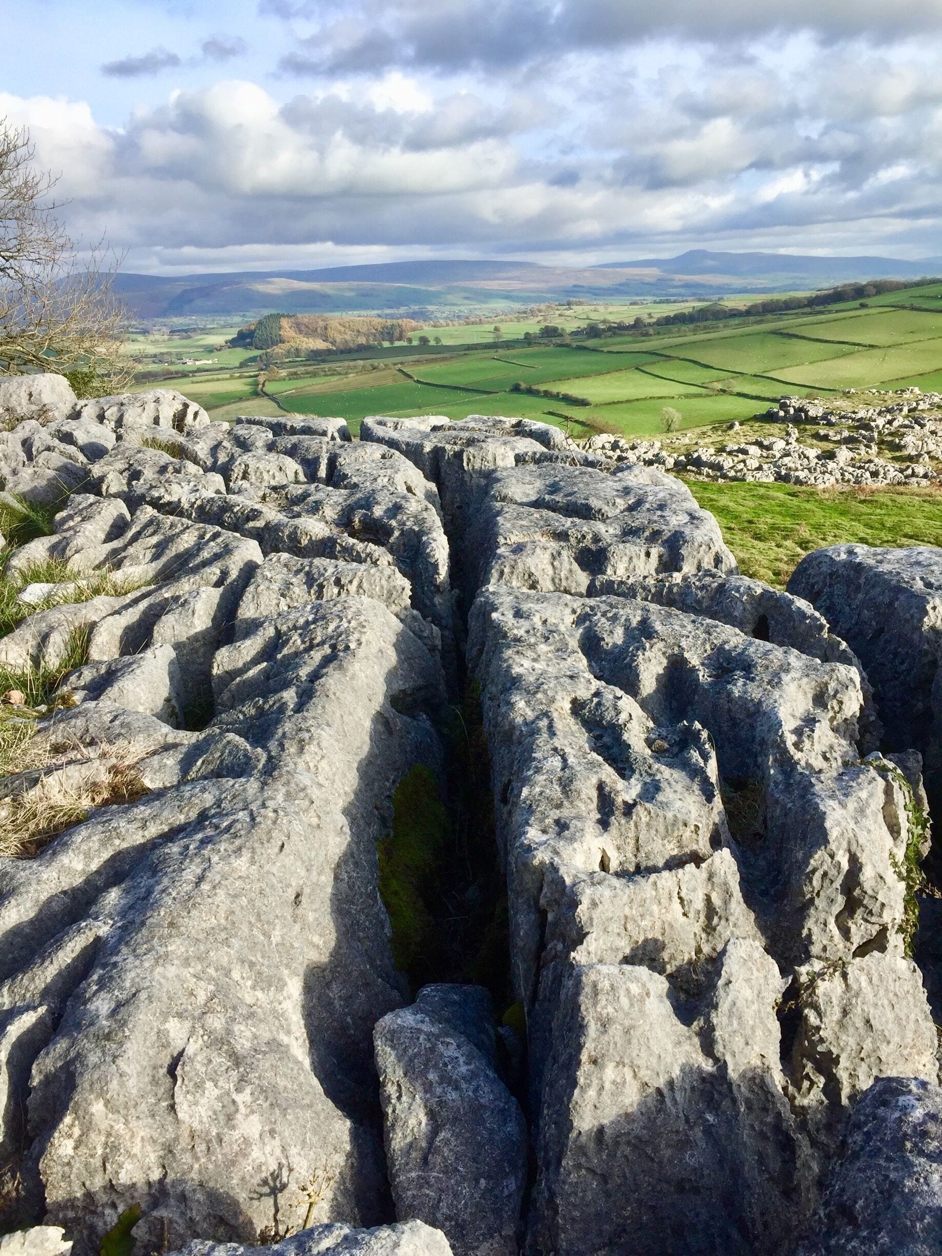 A rocky landscape with a valley and distant hills.