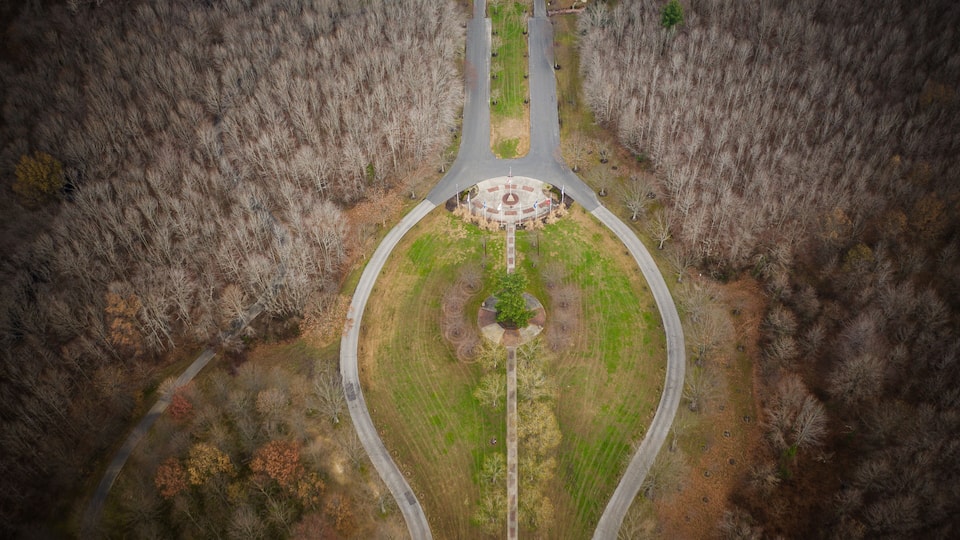 An aerial view of a roundabout surrounded by forested areas.