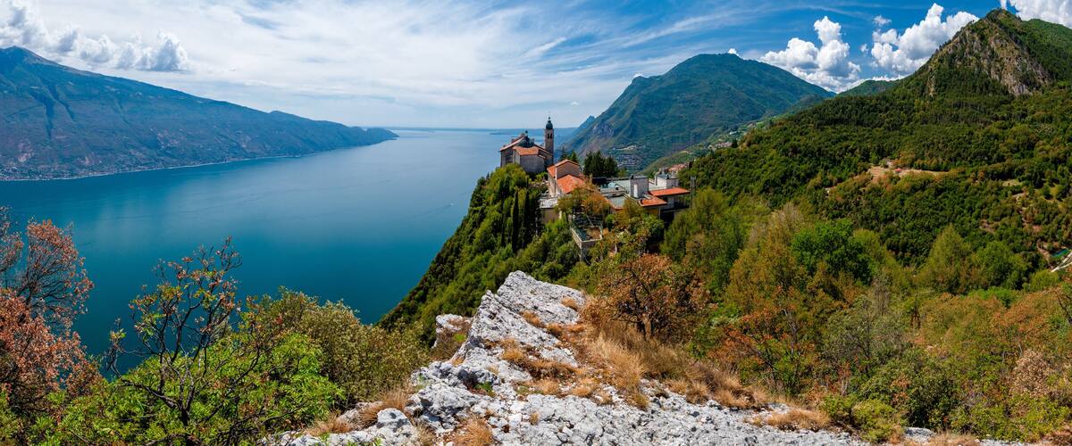 A mountainous landscape with a lake, a church, and a rocky outcrop.