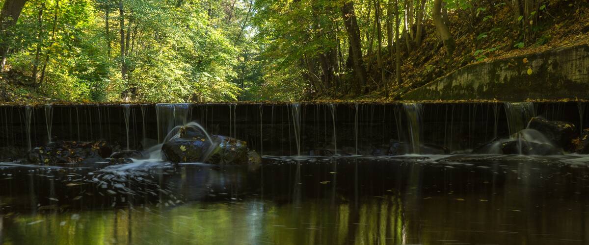 A waterfall cascading over rocks in a forested area.