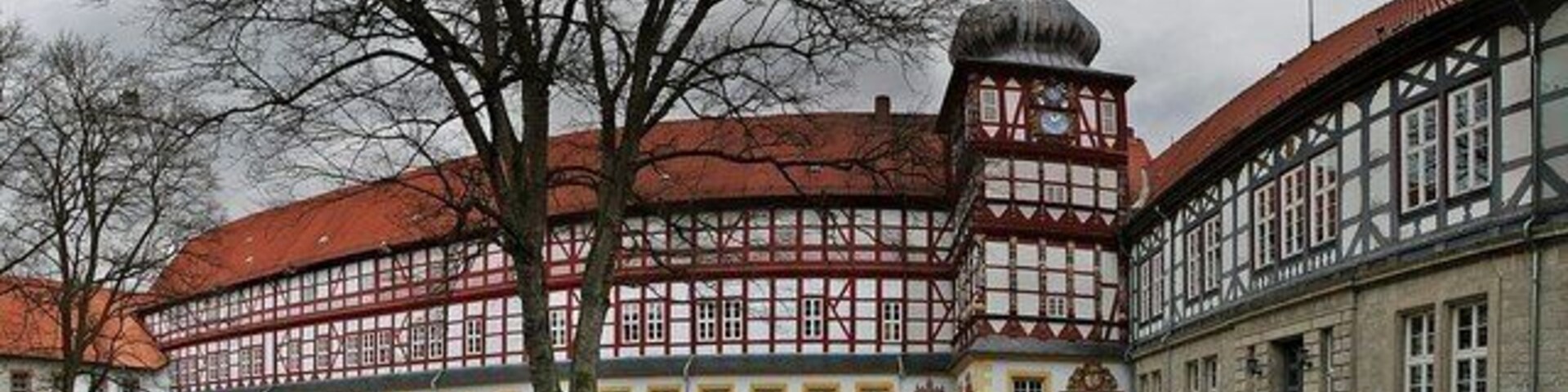 A historic building with a red-tiled roof and a prominent tower.