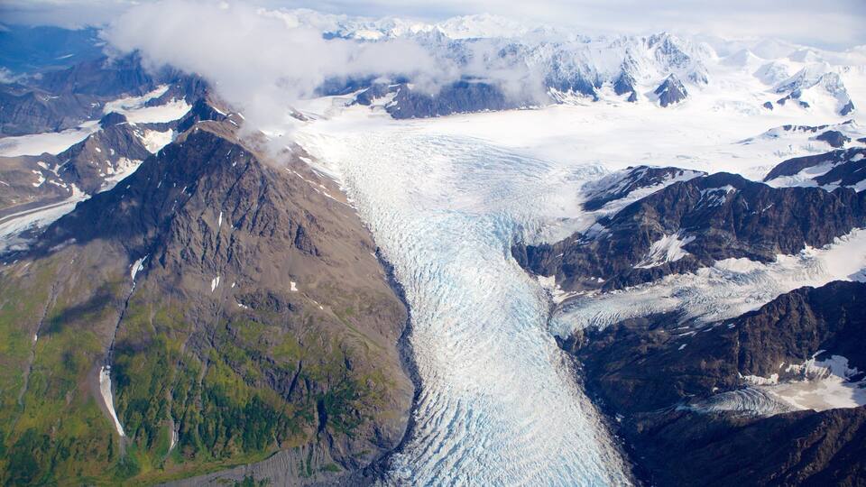 A glacier flowing between mountains.