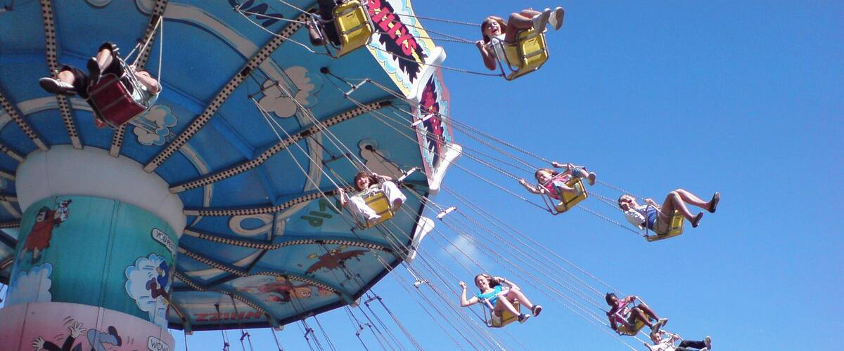 A carousel with children and adults enjoying the ride.