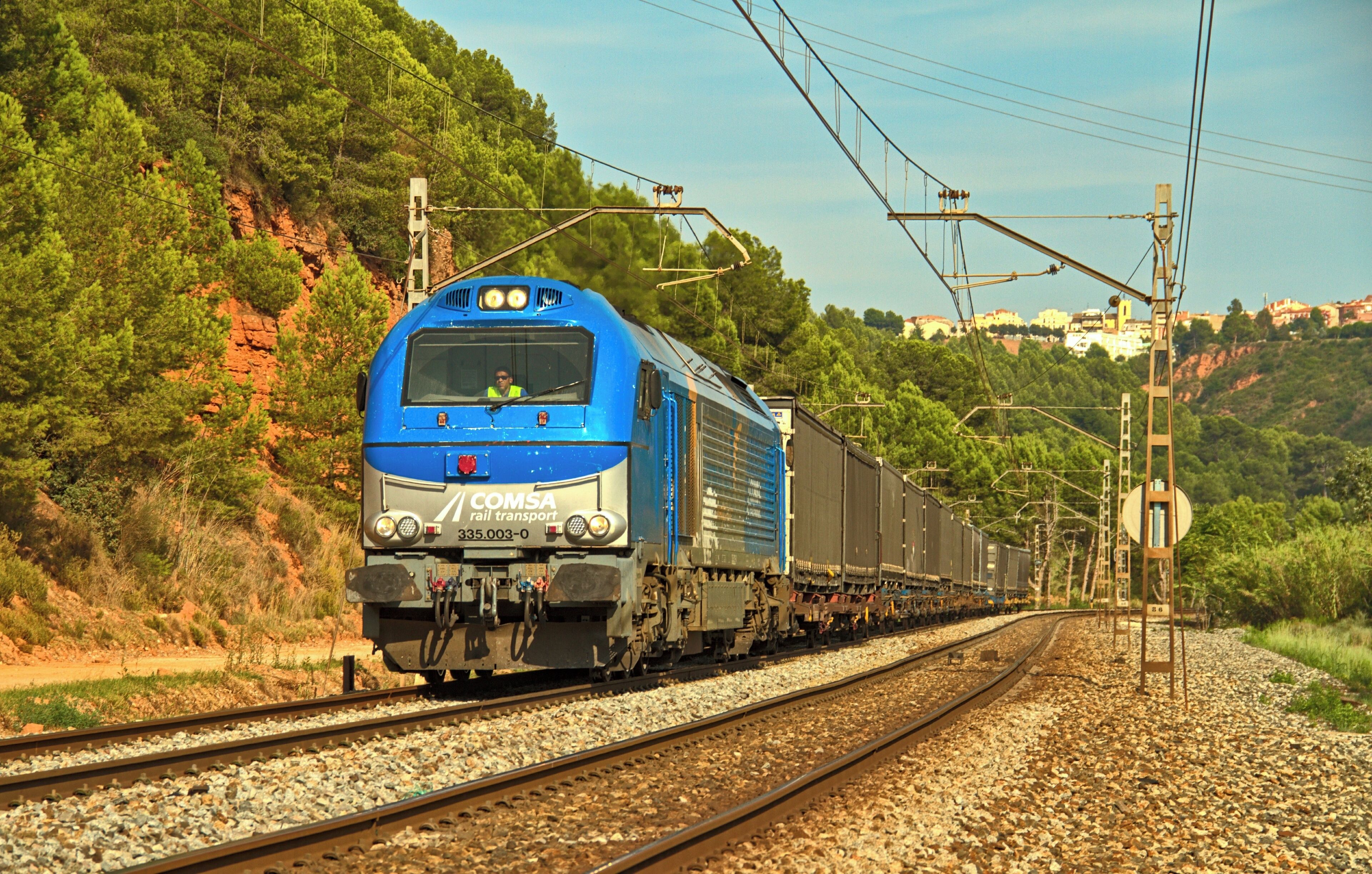 La locomotora diésel-eléctrica locomotora 335.001 de Comsa (Euro 4000 de Vossloh) con un tren de mercancías por la línea 240 de Adif de Sant Vicenç de Calders a L'Hospitalet de Llobregat a la altura de Castellbisbal.