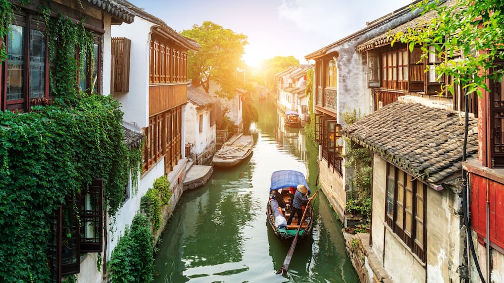 A narrow waterway flanked by traditional buildings with wooden windows and tiled roofs.