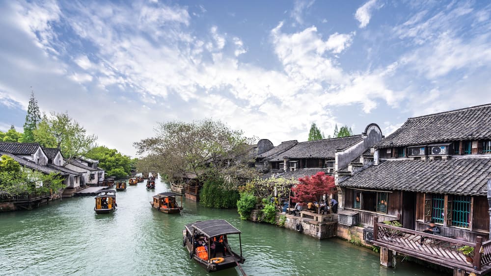 A traditional riverside town with wooden boats and houses along the water.