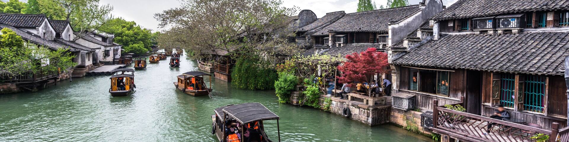 A traditional riverside town with wooden boats and houses along the water.