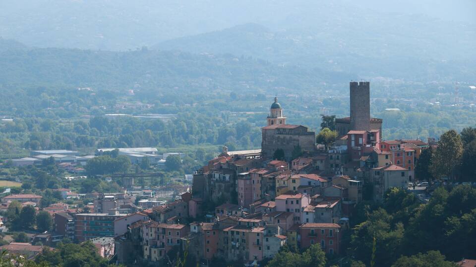 Village of Arcola with the pentagonal tower and in the background the valley of the Magra river and the Apuan Alps.