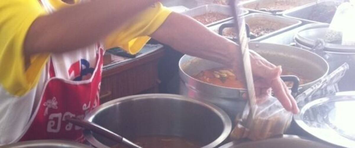 A person cooking with multiple pots and pans.