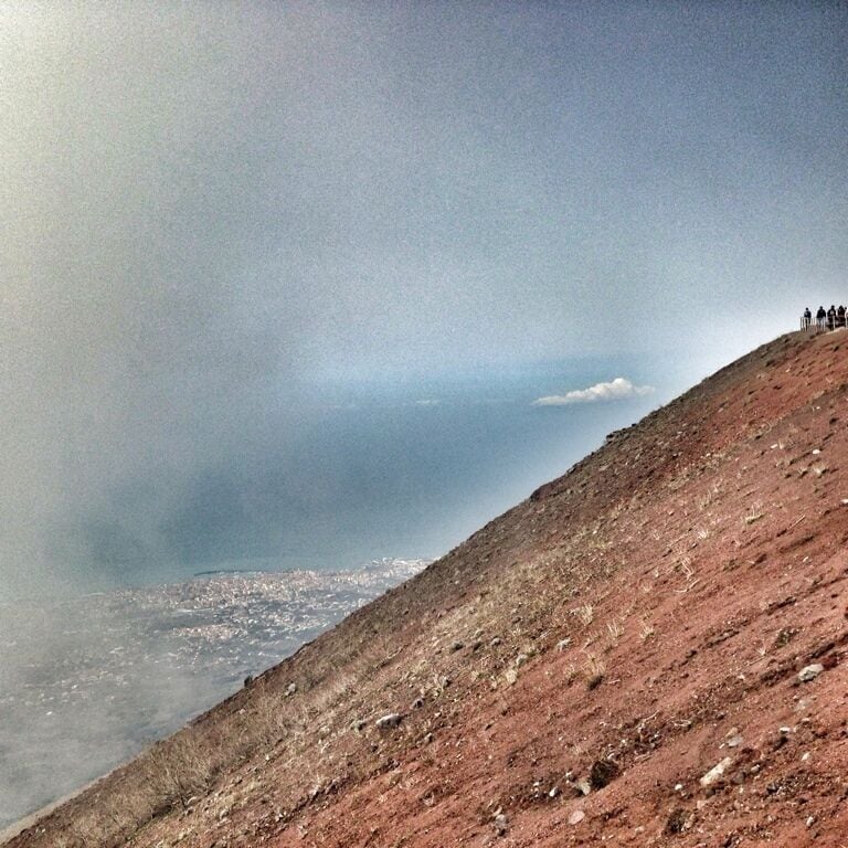 A rocky hillside with a group of people at the top.