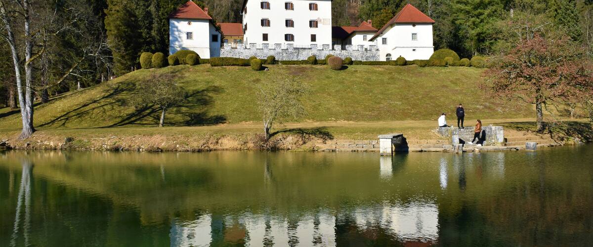 View of Strmol castle near Cerklje na Gorenjskem in Slovenia and a reflection of the catle in the lake in front