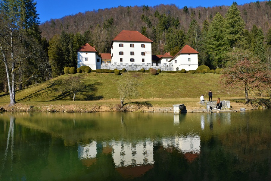 View of Strmol castle near Cerklje na Gorenjskem in Slovenia and a reflection of the catle in the lake in front