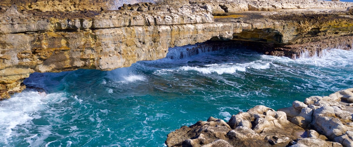 Devil\'s Bridge featuring surf, rugged coastline and general coastal views