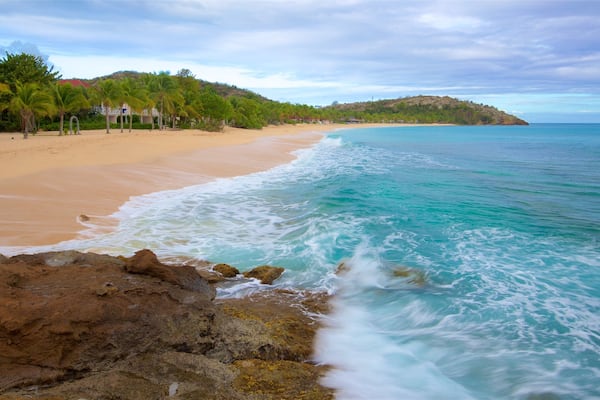 Galley Bay ofreciendo vistas generales de la costa, costa escarpada y una playa de arena