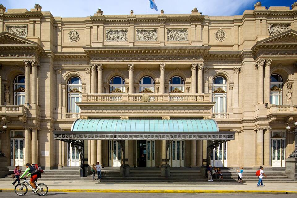Un imponente edificio neoclassico con un grande ingresso ad arco e una tenda blu.