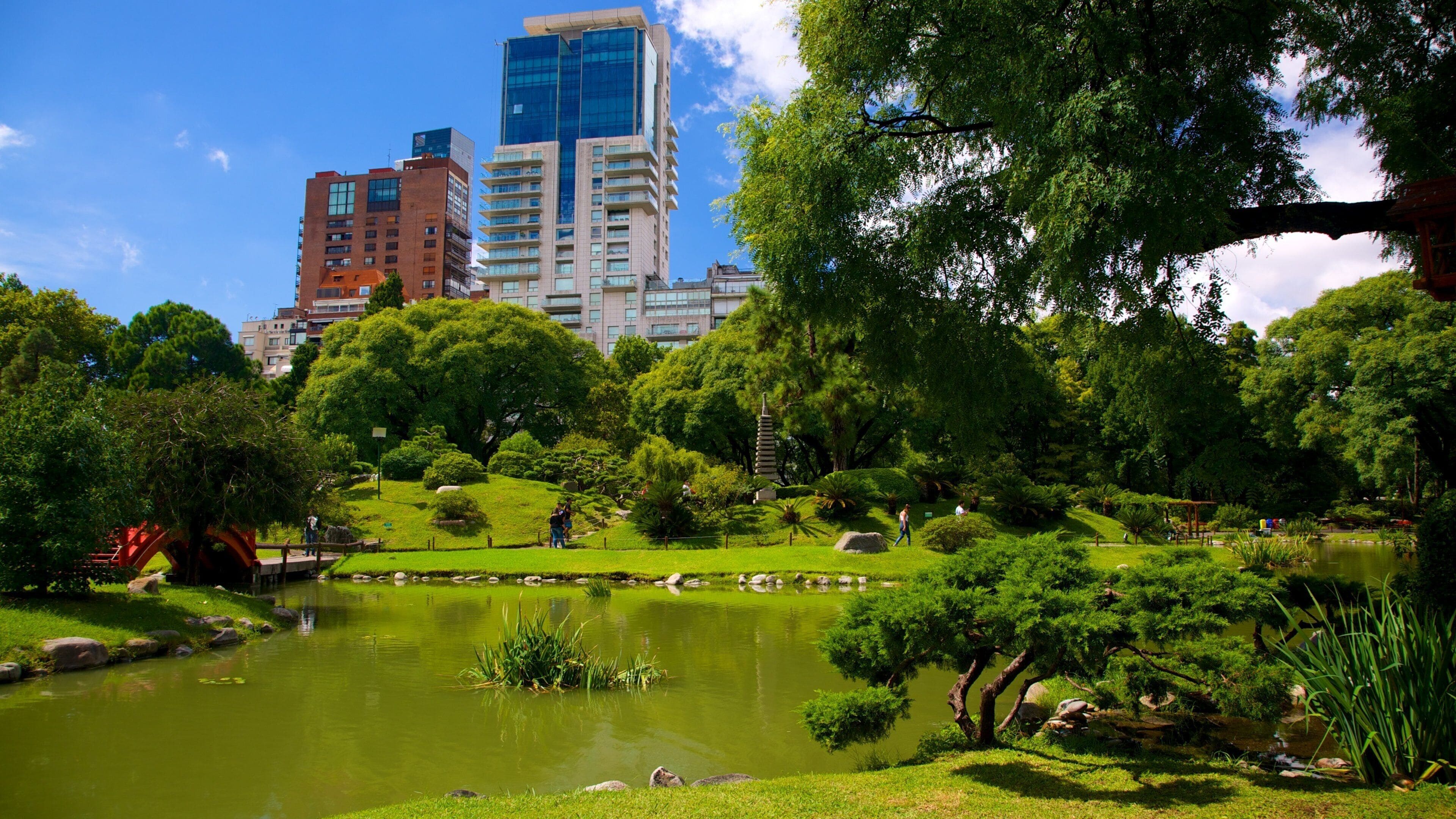 A park with a pond, trees, and a pagoda.