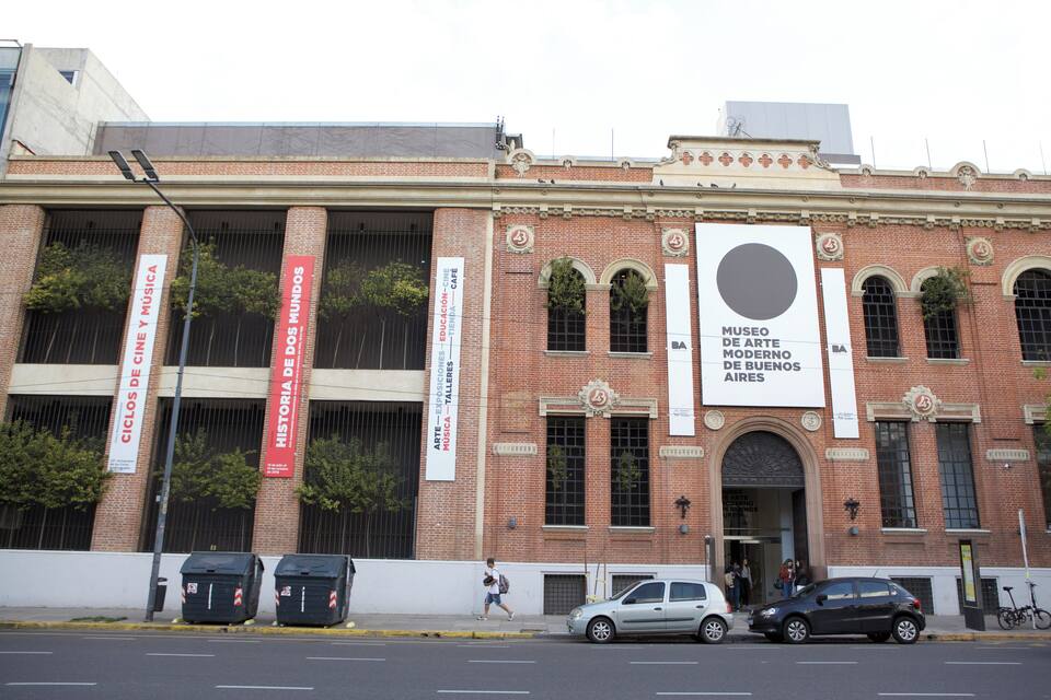 A historic building with large banners and a prominent circular sign.