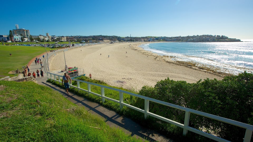 A coastal beach with a promenade, ocean waves, and buildings in the background.