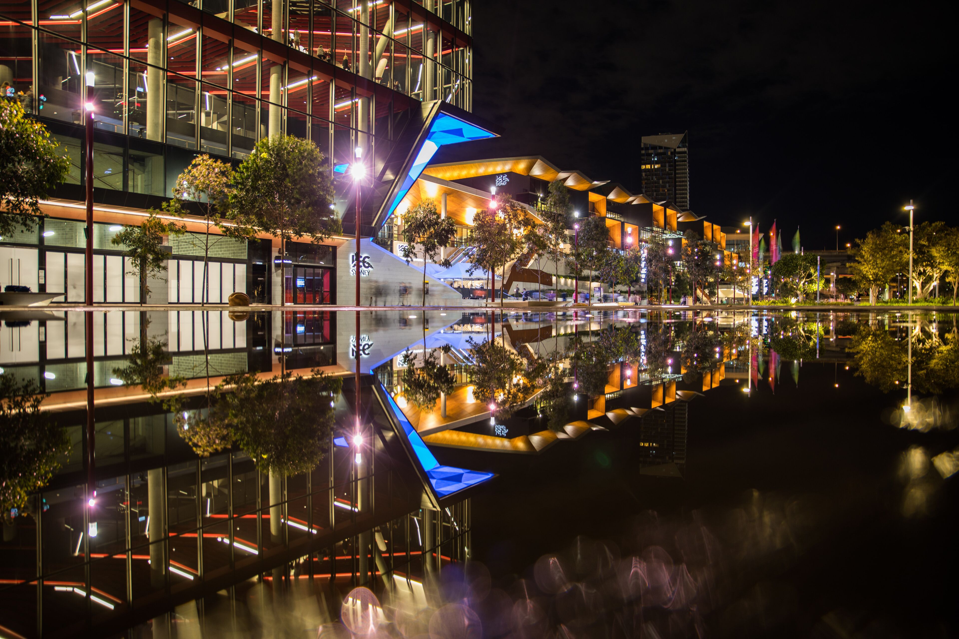 Wet pavement reflection of the new International Convention Centre Sydney illuminated at night