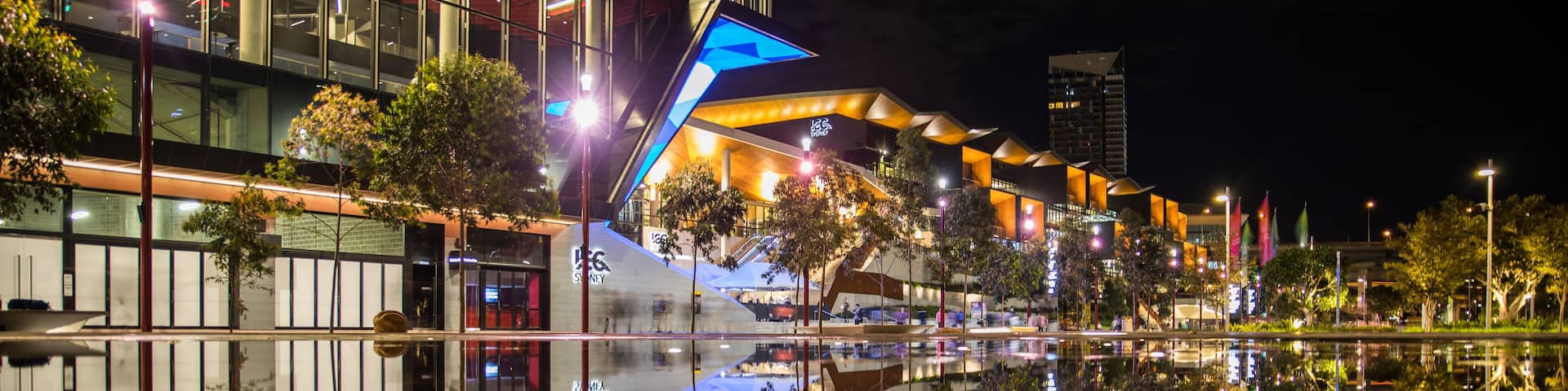 Wet pavement reflection of the new International Convention Centre Sydney illuminated at night