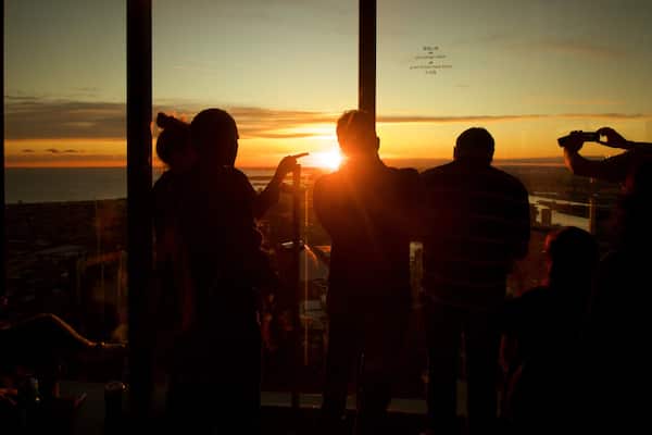 Eureka Tower which includes views and a sunset as well as a small group of people