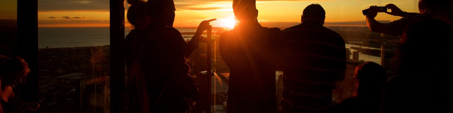 Eureka Tower showing a sunset and views as well as a small group of people