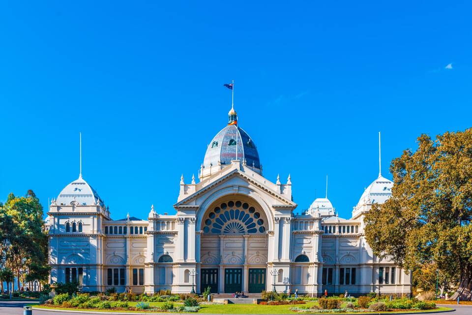 A large, ornate building with multiple domes and a central arched entrance.
