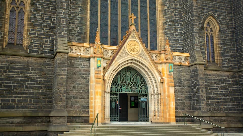 Una iglesia de estilo gótico con una gran entrada en arco, paredes de piedra y vidrieras.