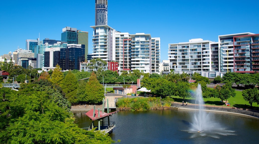 Roma Street Parkland mostrando horizonte, un edificio alto y un estanque