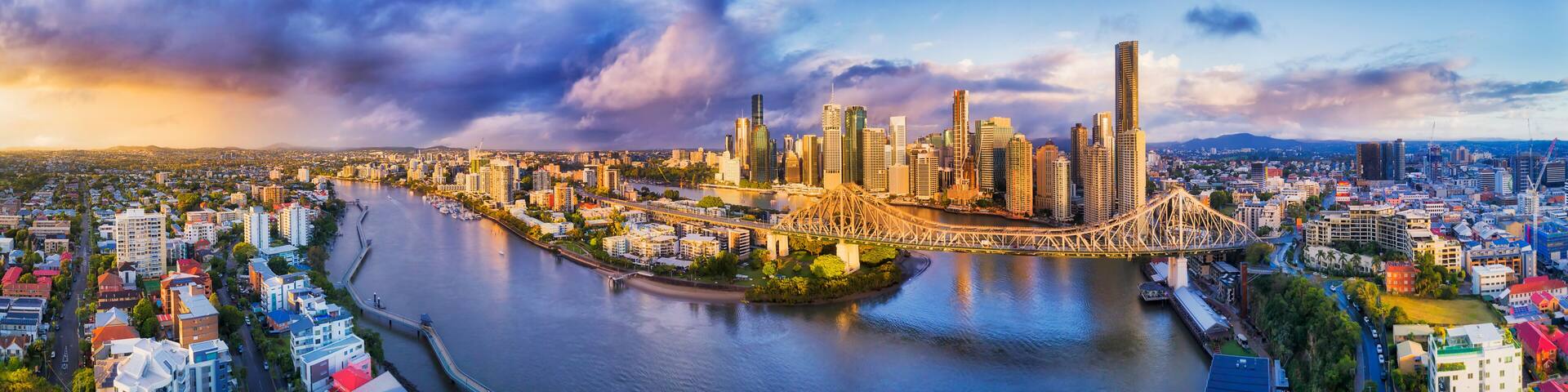 A cityscape with a river, a prominent bridge, and high-rise buildings.