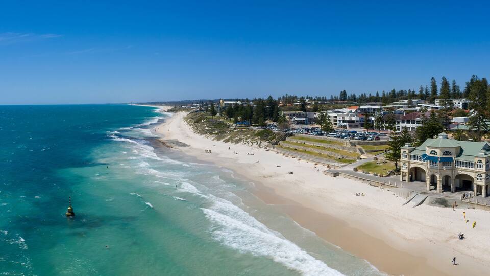 Un pueblo costero con playa, océano y edificios residenciales.