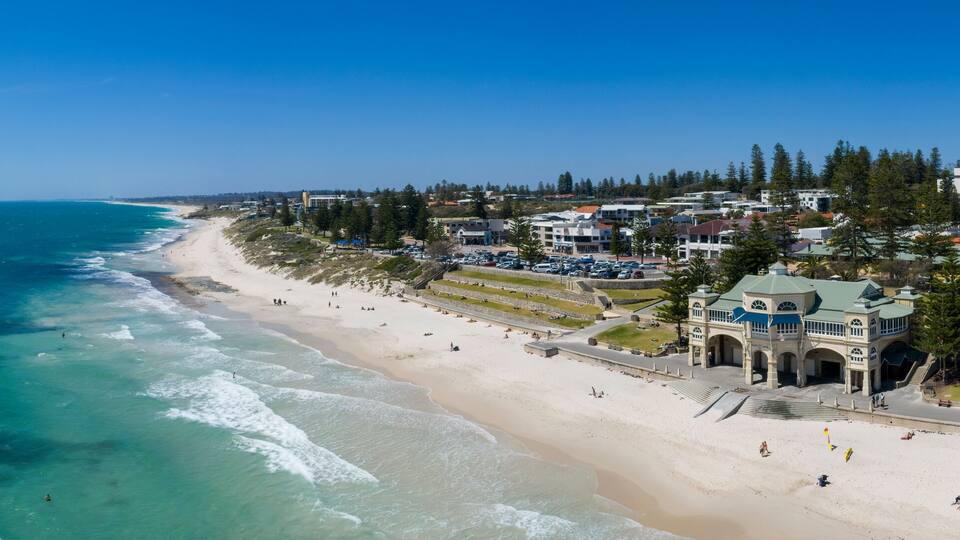 Un pueblo costero con playa, océano y edificios residenciales.