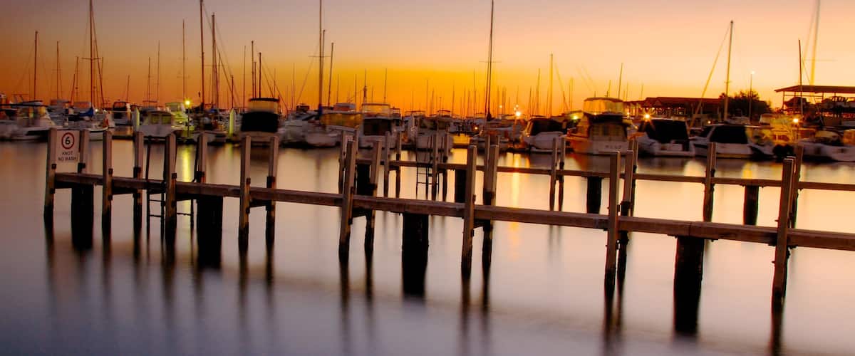Hillarys Boat Harbour showing a coastal town, a sunset and a bay or harbor