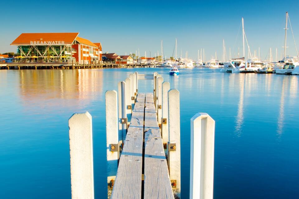 Un puerto deportivo con un muelle de madera que conduce a un edificio con la leyenda "Breckwater".
