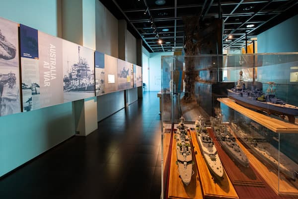 Un espace d’exposition présentant des objets historiques, notamment des photographies et des maquettes de navires.