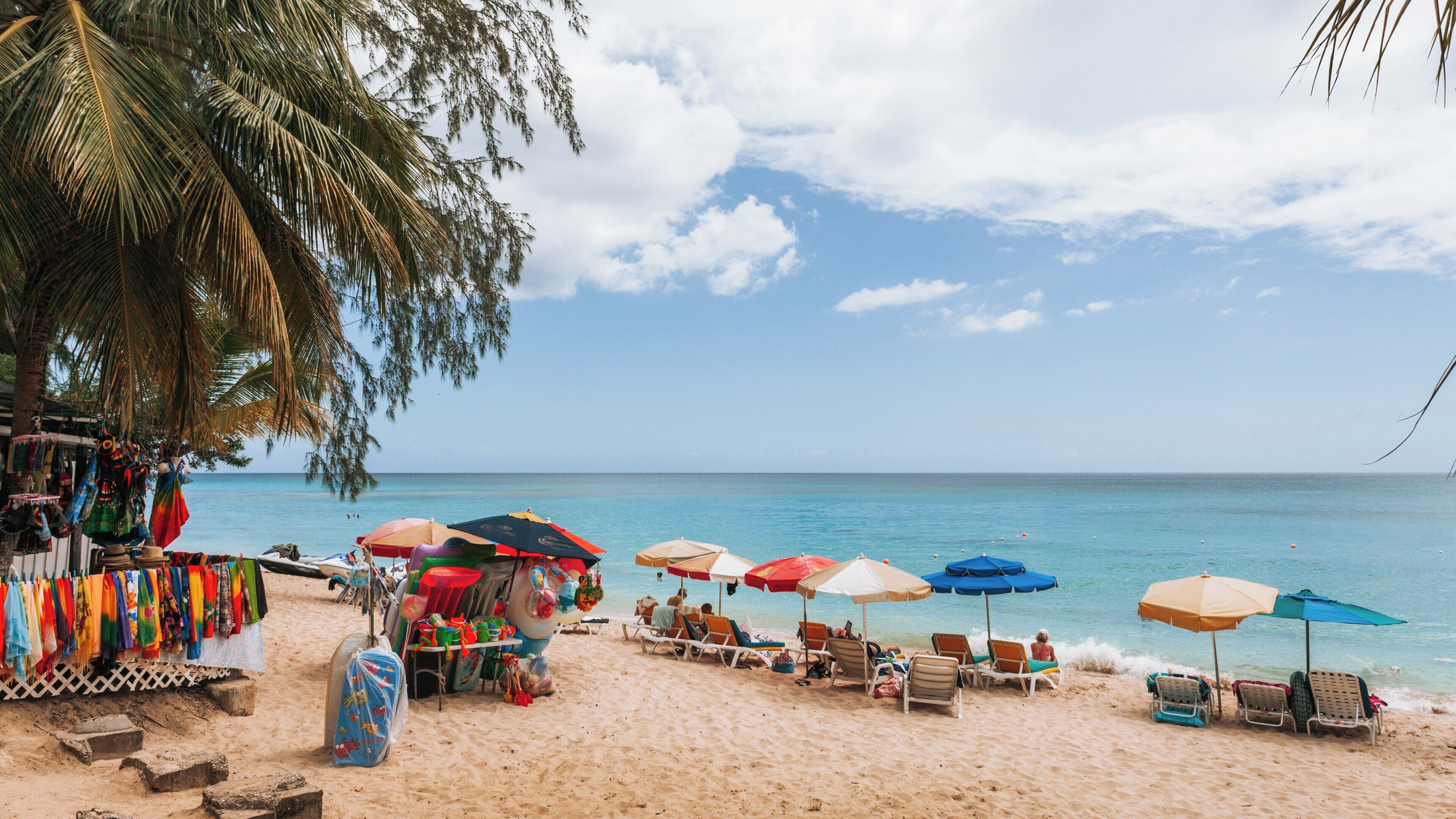 Brighton Beach in Bridgetown, St. Michael, Barbados offers beautiful sands, colorful umbrellas, and a relaxing atmosphere for visitors enjoying the Caribbean sun