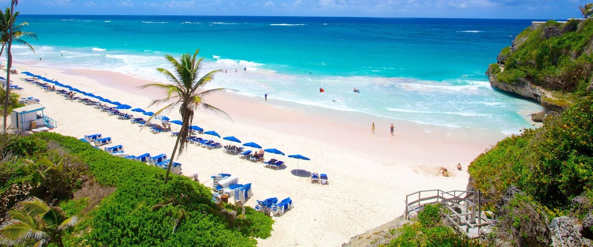 A beach with turquoise water, white sand, and palm trees.