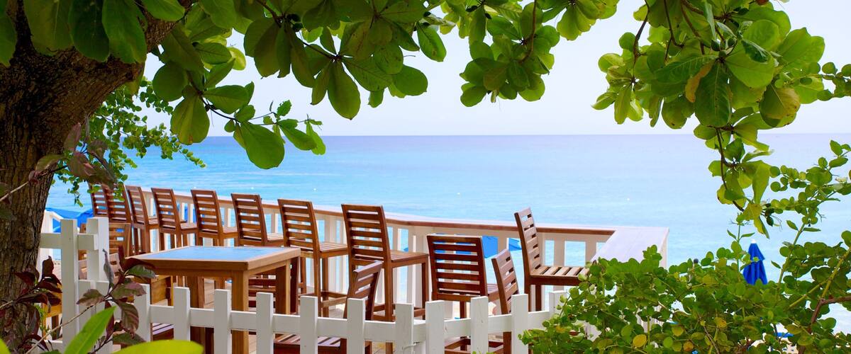 A wooden deck with chairs overlooking the ocean.