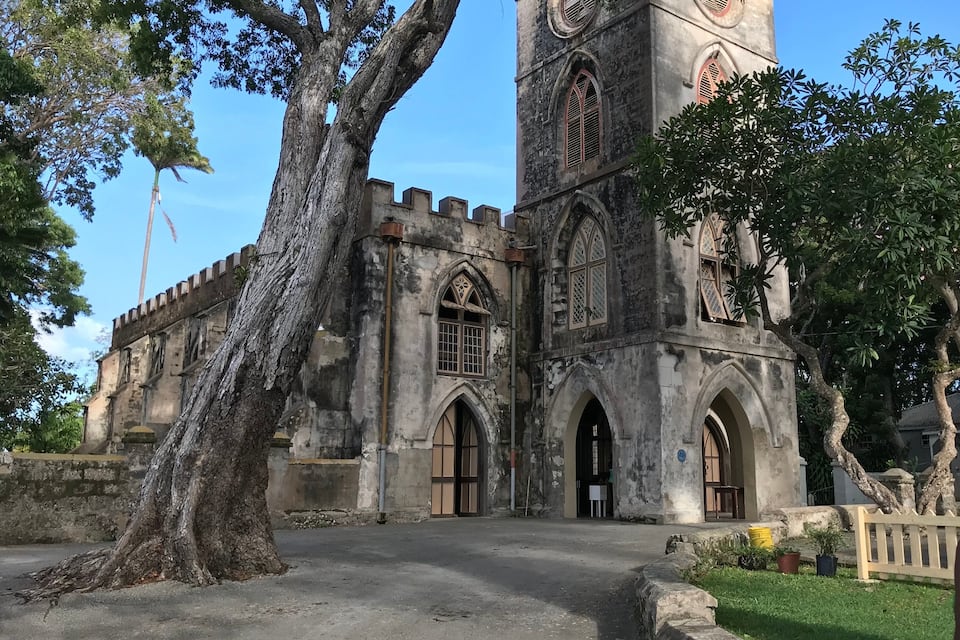 Uma igreja histórica com janelas em arco e uma torre do relógio.