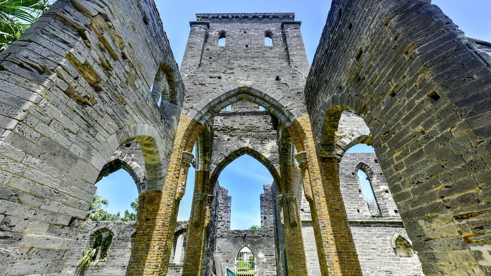 An ancient stone structure with arched passageways and a tower.