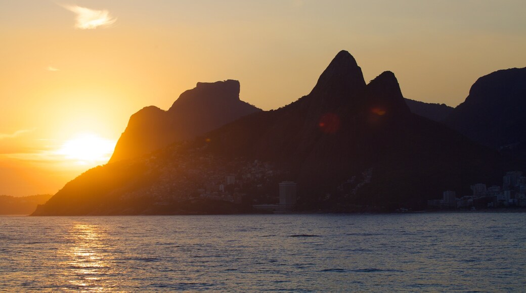 Praia do Arpoador que inclui montanhas, paisagens litorâneas e um pôr do sol