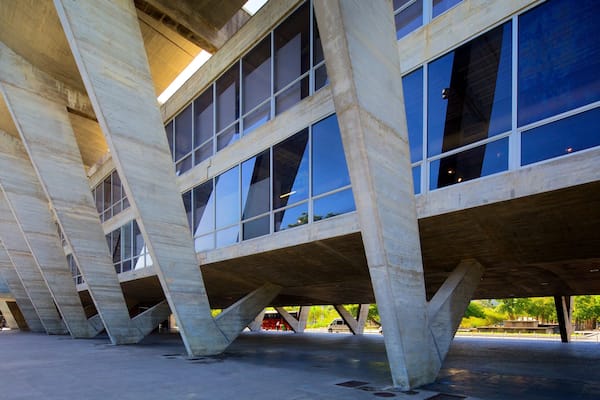 Une structure architecturale moderne au design original, caractérisée par des piliers en béton et de grandes fenêtres.