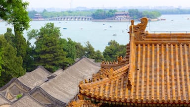Traditionelle chinesische Architektur mit aufwendigen Dächern und einem Fluss mit Booten.