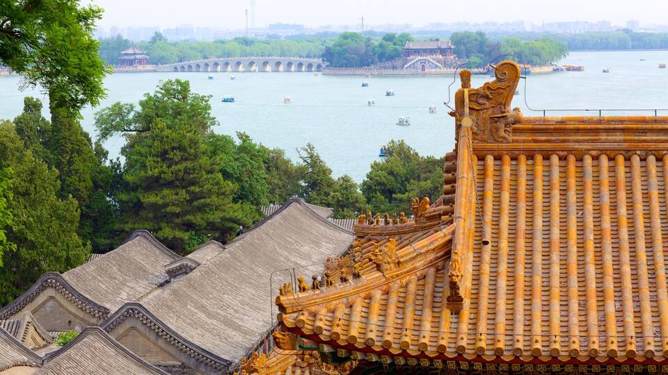 Traditional Chinese architecture with ornate roofs and a river with boats.
